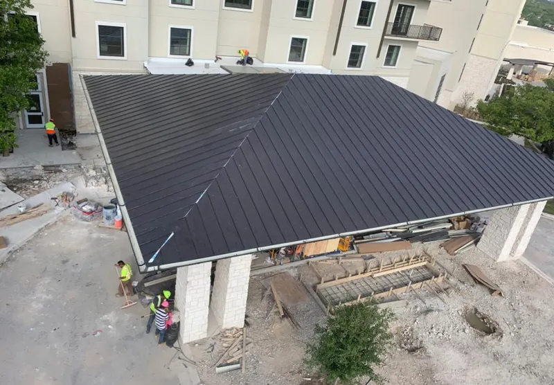 Metal roofing installation team working on a commercial building in Atlas
